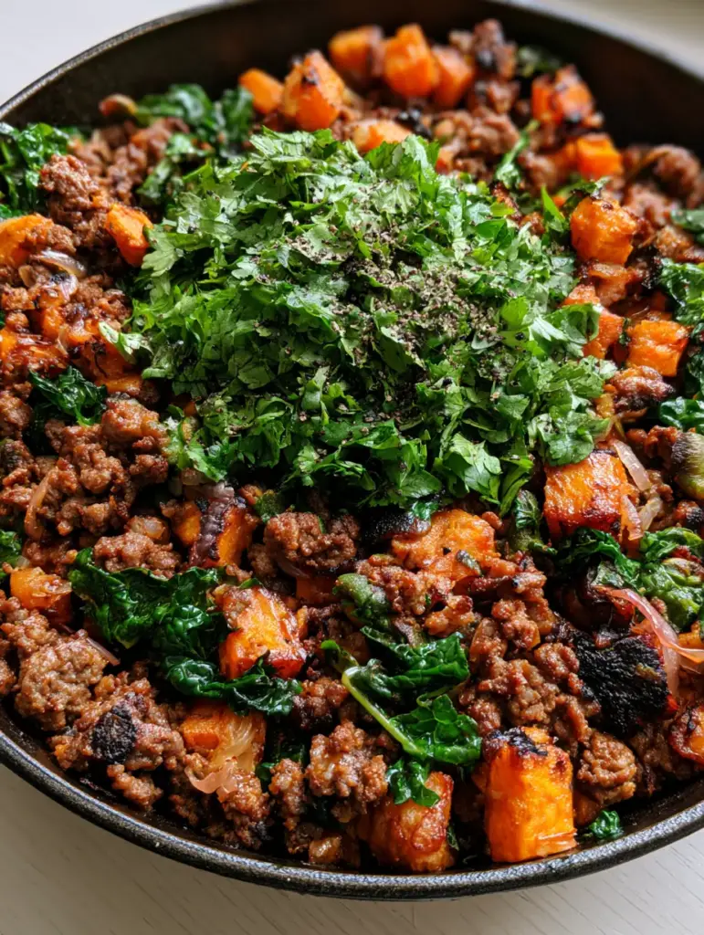 Ground Beef Sweet Potato Bowl with Wilted Kale and Caramelized Onions 1 Vibrant dark green kale and red onion slivers folded into a ground beef sweet potato bowl.