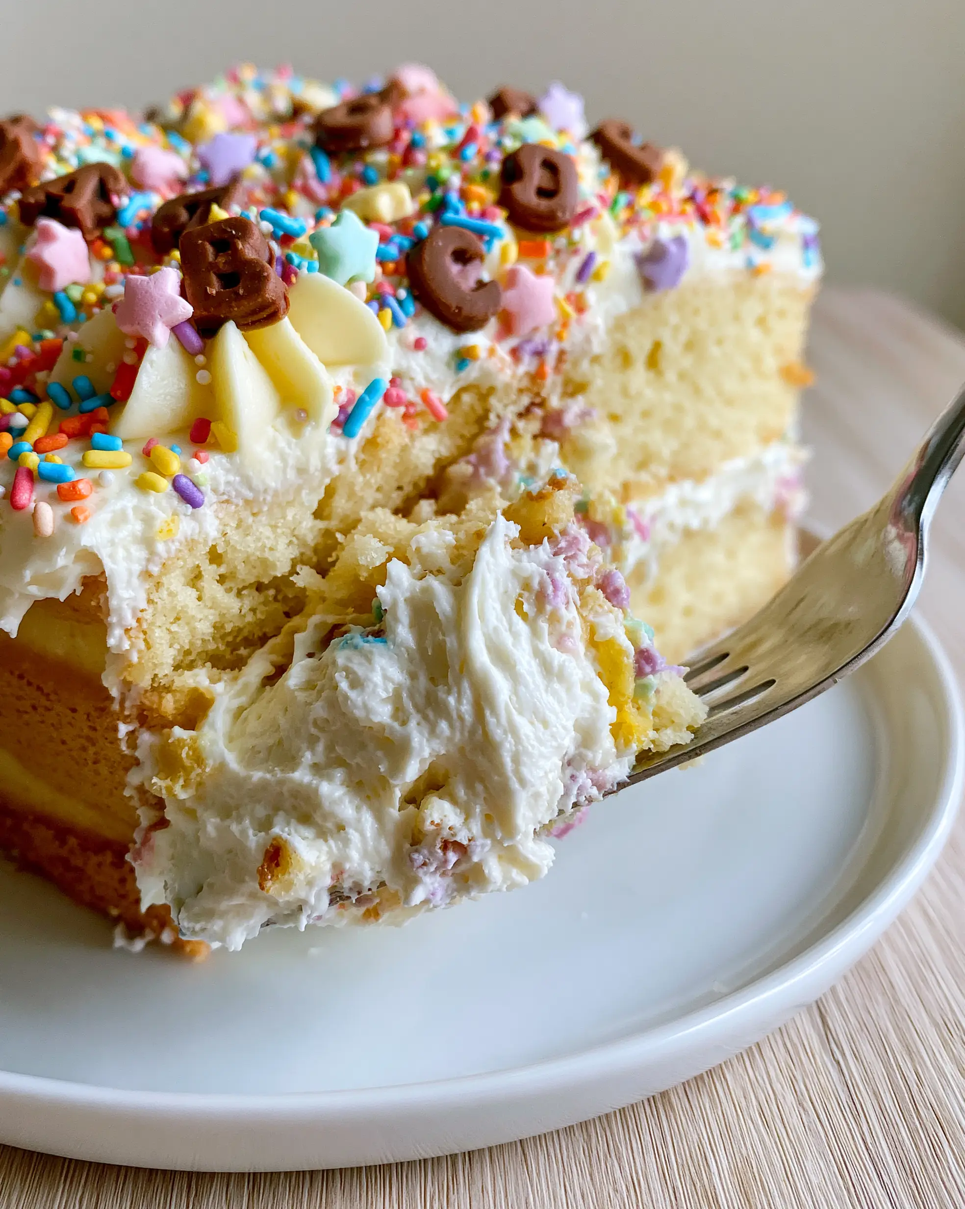 A close-up slice of Einschulungskuchen showcasing the creamy whipped cream pull and golden sponge.