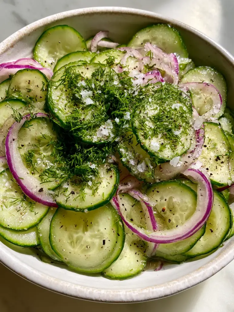 Cucumber Onion Salad with Fresh Dill and Light Vinaigrette 2 Translucent slices of Persian cucumbers and purple red onion rings coated in a light vinaigrette. (cucumber onion salad)