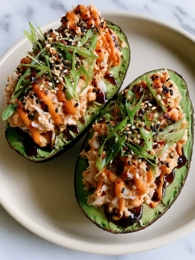 Spicy Crab Stuffed Avocado: The Ultimate High-Protein Umami Lunch 2 Top-down view of spicy crab stuffed avocado with sesame seeds and scallions on a white marble background. (spicy crab stuffed avocado)