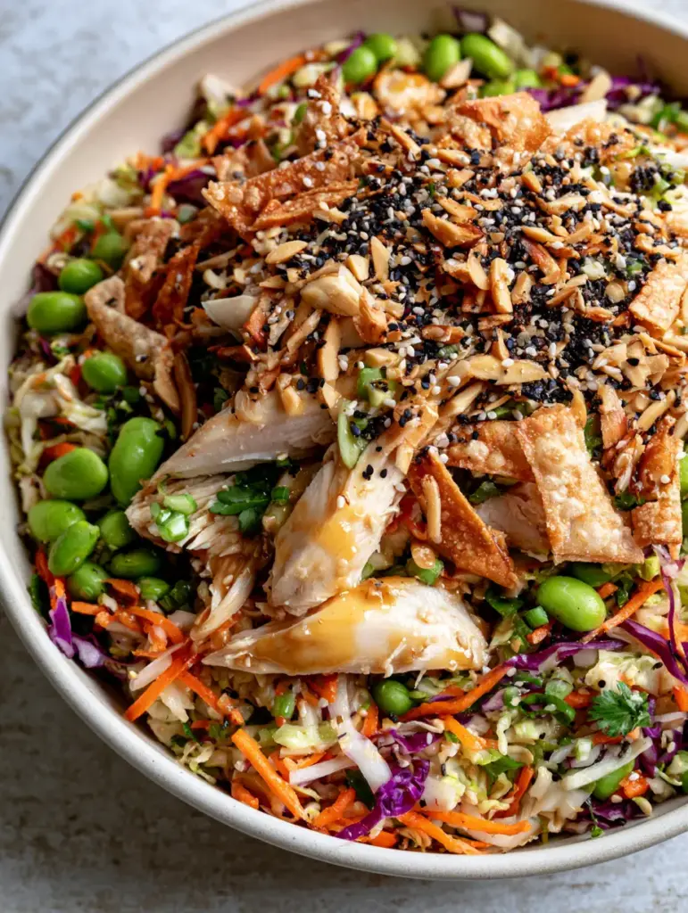 Asian crunch chicken salad: The Ultimate Restaurant-Style Recipe 2 Extreme close-up of Asian crunch chicken salad showing glistening dressing and black sesame seeds.