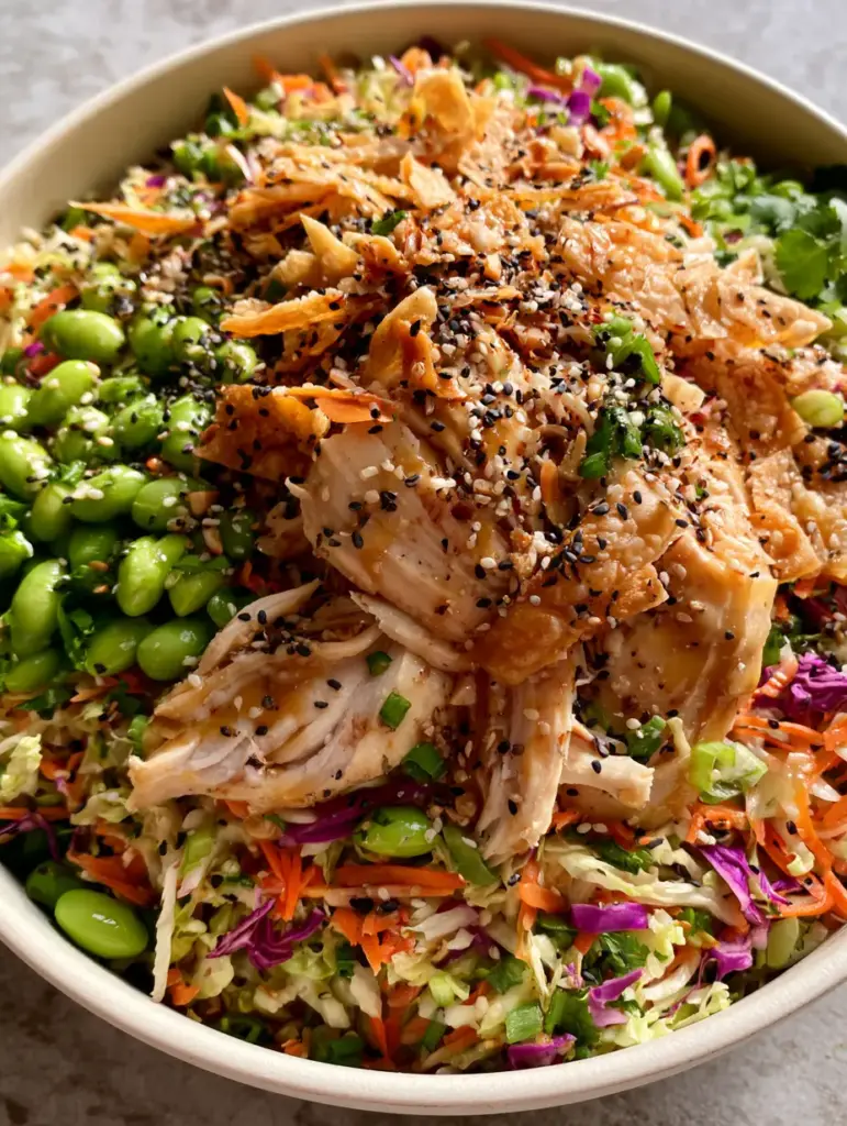 Asian crunch chicken salad: The Ultimate Restaurant-Style Recipe 1 Wide shot of Asian crunch chicken salad in a matte ceramic bowl on a stone surface.