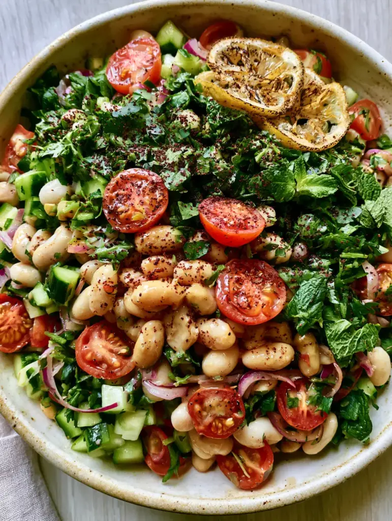 White Bean Salad with Lemon-Tahini Dressing and Charred Lemon 2 Close up of glossy cannellini beans tossed with lemon tahini dressing and vibrant herbs. (white bean salad)