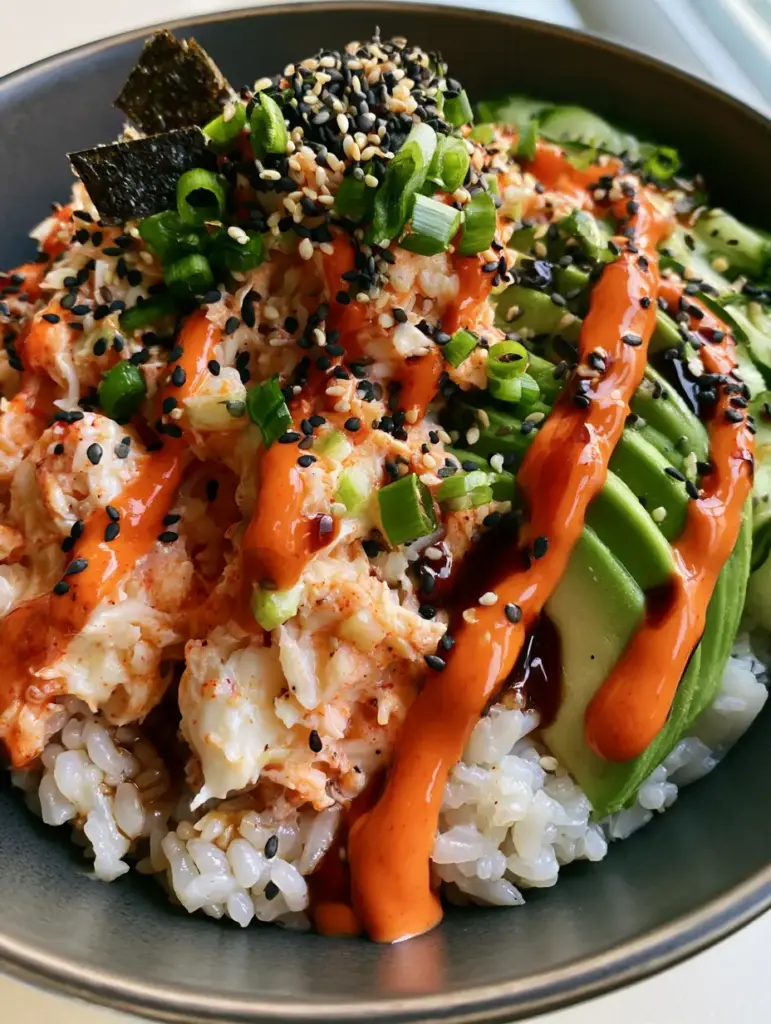 Spicy Crab Sushi Bowls with Creamy Kani and Sriracha Mayo 1 Top-down view of Spicy Crab Sushi Bowls showing the contrast between bright orange sriracha and green scallions.