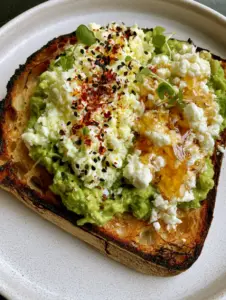 Extreme close-up of Avocado Toast Recipe showing charred sourdough edges and vibrant green chunky avocado.