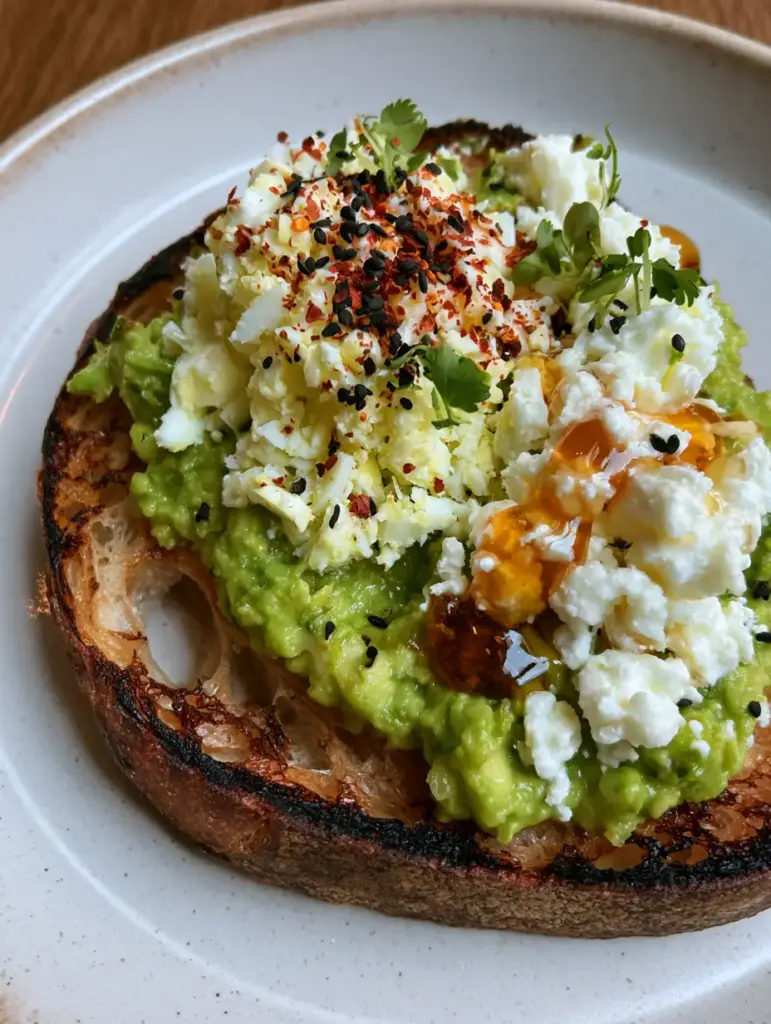 Avocado Toast Recipe with Grated Egg, Feta, and Hot Honey 1 Gourmet Avocado Toast Recipe topped with fluffy grated egg mountain and creamy crumbled feta.