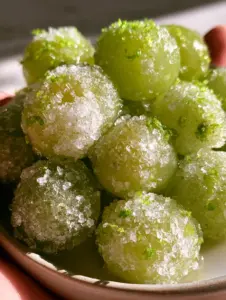 Close up of frozen grapes showing chunky sweetener crystals and microscopic ice crystals on the skin. (frozen grapes)