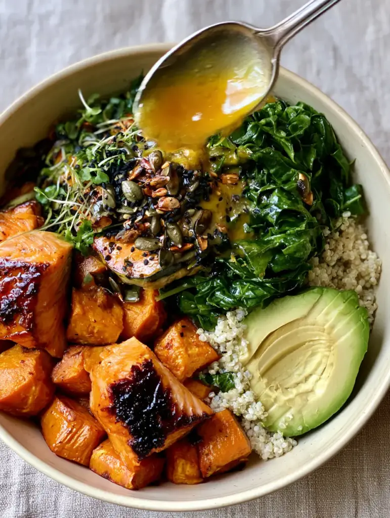 High Protein High Fiber Dinners: The Ultimate Honey-Seared Salmon Power Bowl 1 Close-up of golden lemon-tahini dressing being poured from a spoon over a salmon power bowl.