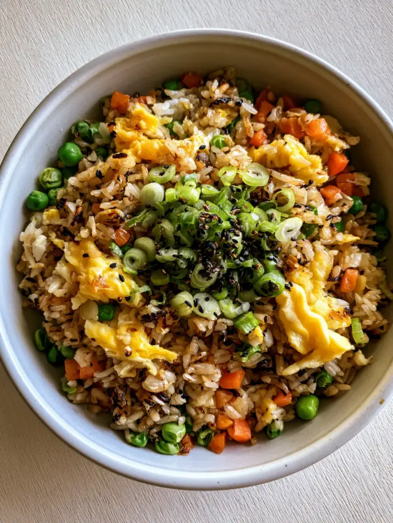 Egg Fried Rice with Golden Toasted Grains and Fluffy Egg Ribbons 2 Close-up of egg fried rice showing individual toasted jasmine rice grains with visible char marks and fluffy bright yellow egg ribbons.