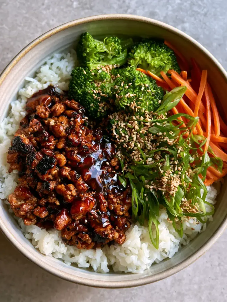 Ground Turkey Teriyaki Rice Bowls with Caramelized Edges 1 Detailed close-up of charred ground turkey crumbles with a thick mahogany-colored teriyaki sauce.