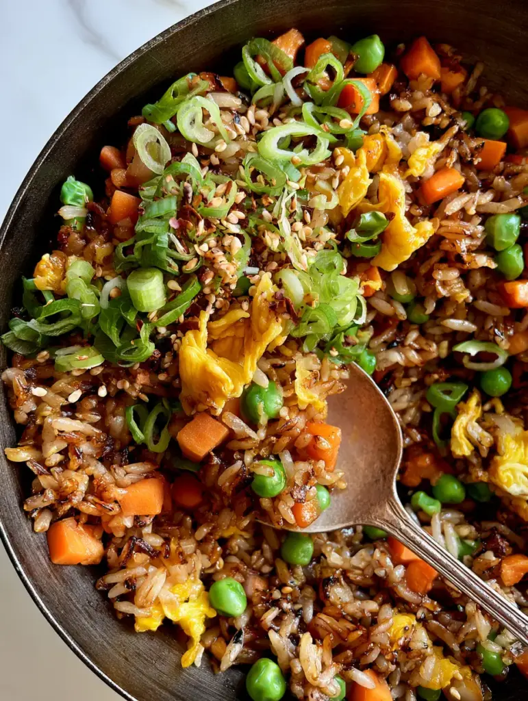 Easy Fried Rice with Glistening Soy Sauce Glaze and Wok-Seared Jasmine Rice 1 Extreme close-up of Easy Fried Rice with golden scrambled egg ribbons and uniform small-dice carrots.