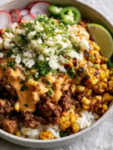 Macro view of seasoned ground beef and charred yellow corn in a Street Corn Beef Bowl.