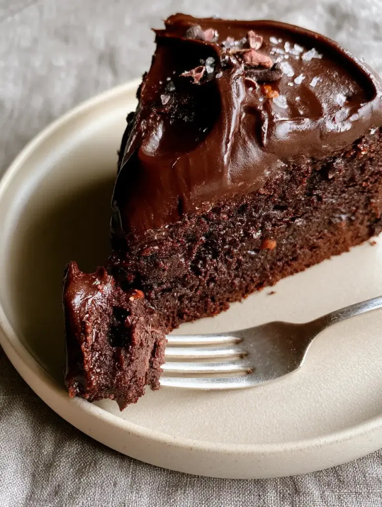 Vegan Chocolate Cake Recipe: The Ultimate Fudgy Dark Chocolate Masterpiece 2 High-angle close-up of a vegan chocolate cake slice showing the moist fudgy crumb and glossy frosting. (vegan chocolate cake recipe)