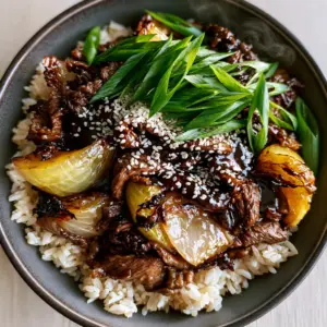 Close up of Beef and Onion Stir Fry showing the velveting texture of the steak and charred edges of the onions. (Beef and Onion Stir Fry)