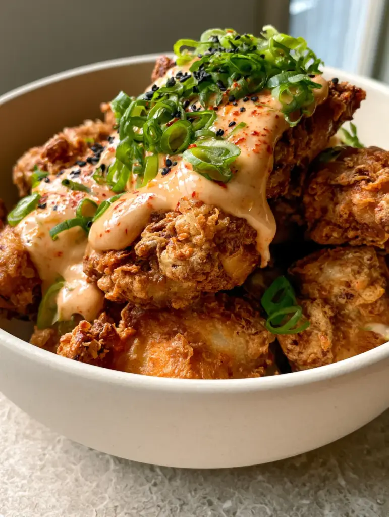 Low Carb Bang Bang Chicken: The Ultimate Extra Crispy Air Fryer Recipe 1 Detailed view of shatter-crisp almond flour coating on air-fried chicken with glossy sauce and red chili specks.