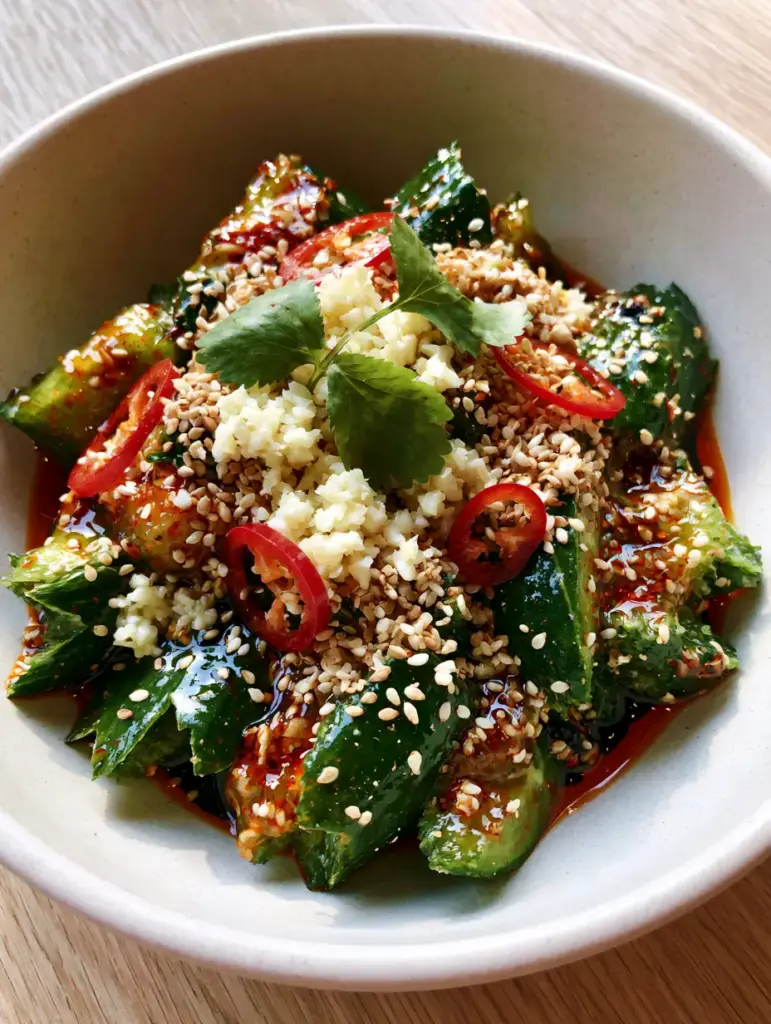 Cucumber Salad Recipes: The Viral Asian Smashed Cucumber Salad 1 Close-up of minced garlic and red chilies on top of a vibrant green cucumber salad. (cucumber salad recipes)