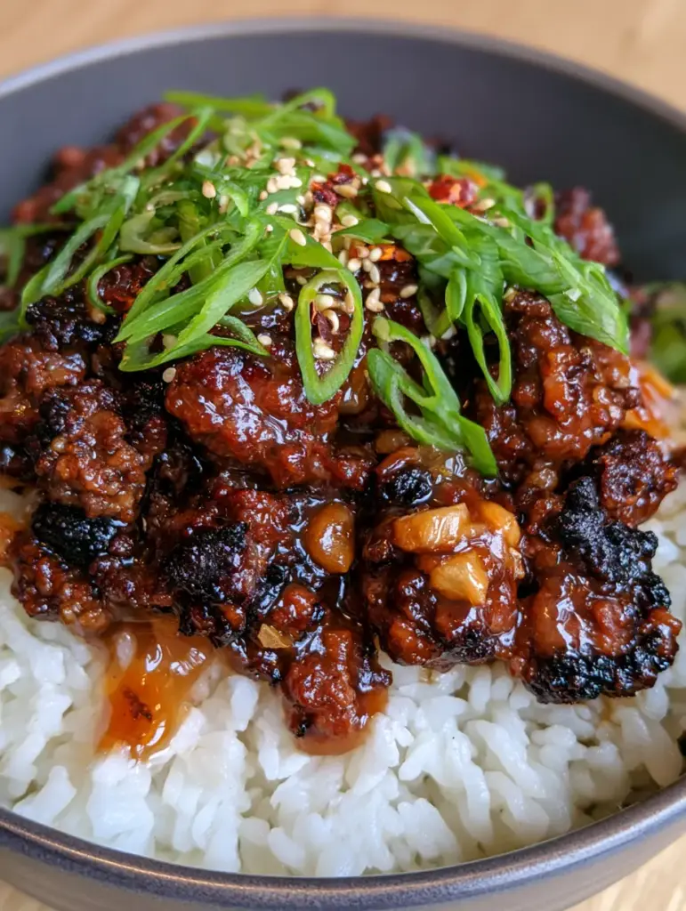 Honey Garlic Ground Beef Bowl with Crispy Caramelized Edges 1 Top-down view of a gourmet honey garlic beef bowl garnished with sesame seeds and chili flakes. (Honey Garlic Ground Beef Bowl)