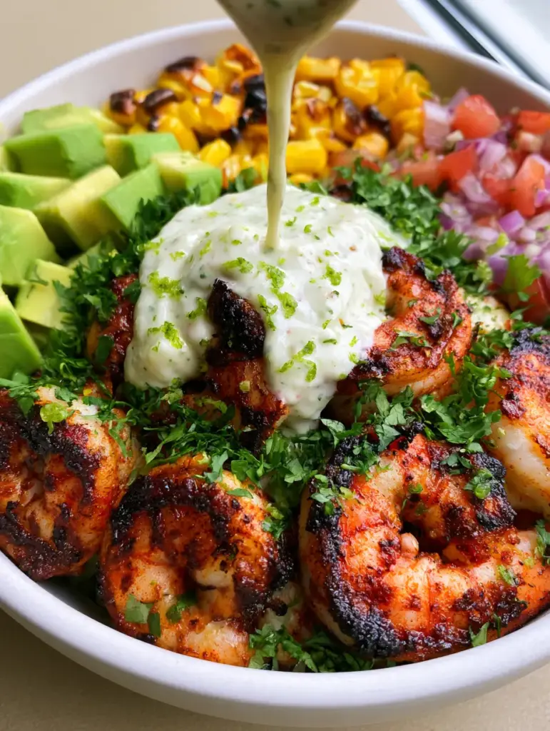 Grilled Shrimp Bowl Recipe with Blackened Jumbo Shrimp and Lime Crema 1 Sectioned bowl with charred corn, avocado, and salsa next to grilled shrimp. (grilled shrimp bowl recipe)