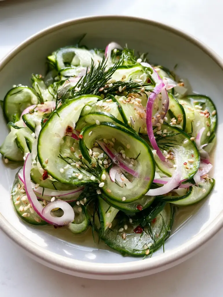 Cucumber Vinegar Salad with Fresh Dill and Toasted Sesame 1 Extreme detail of water droplets and sesame seeds on a glistening cucumber vinegar salad.
