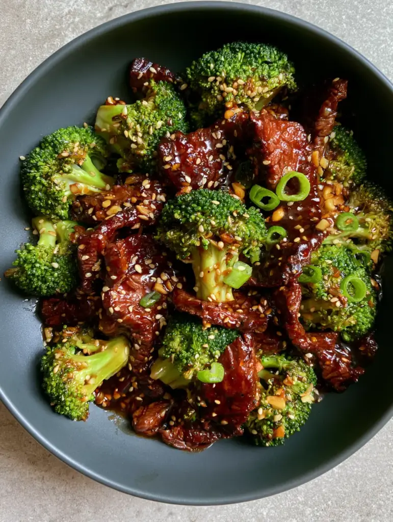 Beef and Broccoli Recipe: The Ultimate Guide to Tender Velveted Steak and Mahogany Glaze 2 Top-down macro shot of velveted flank steak and emerald broccoli in a mahogany soy-ginger glaze. (beef and broccoli recipe)