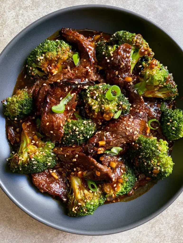 Beef and Broccoli Recipe: The Ultimate Guide to Tender Velveted Steak and Mahogany Glaze 1 Close-up of seared beef and bright green broccoli scattered with white sesame seeds. (beef and broccoli recipe)